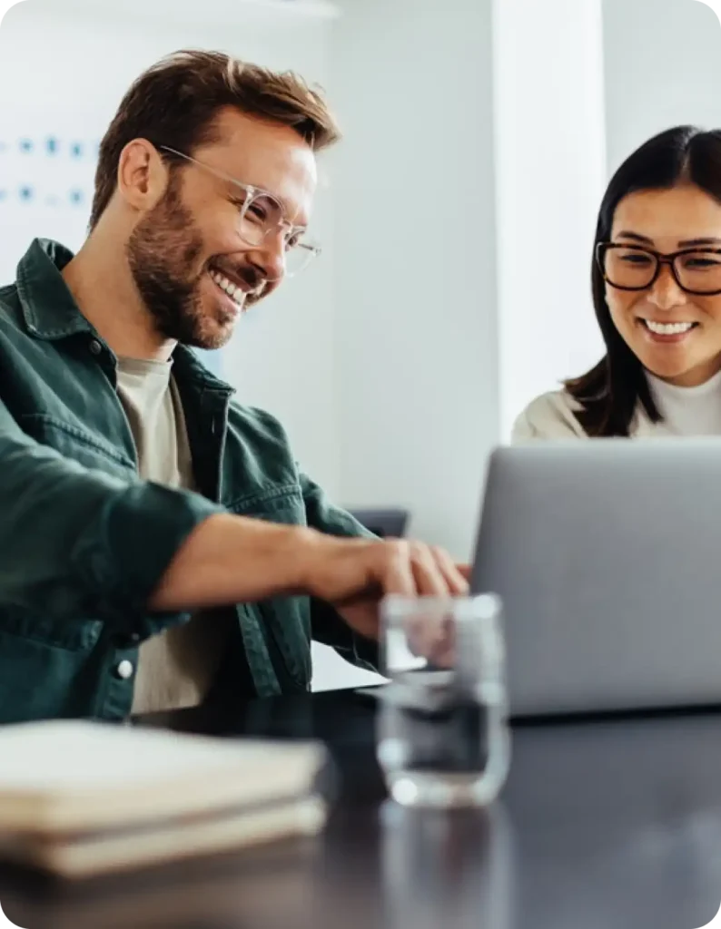 a man and woman looking at a laptop